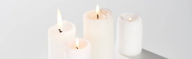 burning candles glowing on white background with shadow, panoramic shot clipart