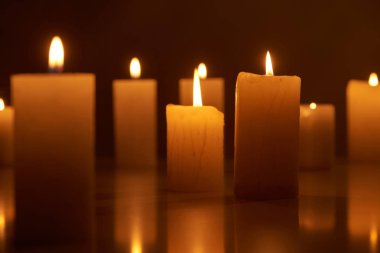 selective focus of burning candles glowing in dark clipart