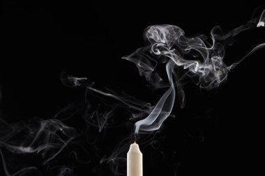 extinct white candle with smoke on black background clipart