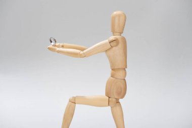 Gri üzerinde gümüş yüzüğü olan tahta kukla.