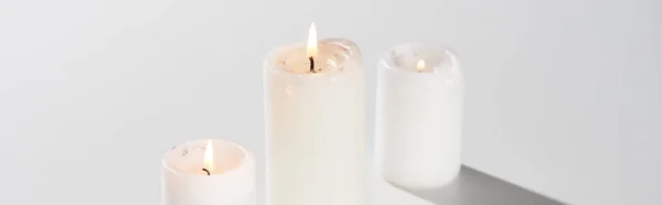 Brandende Kaarsen Gloeiend Witte Achtergrond Met Schaduw Panoramisch Schot — Stockfoto