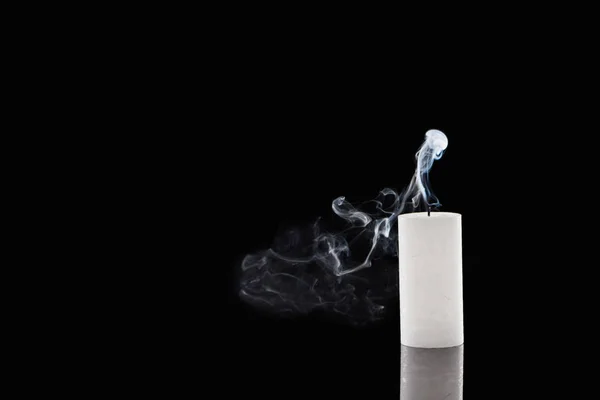熄灭的白色蜡烛 黑色背景上有烟雾 图库图片