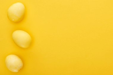 Renkli sarı arka planda boyanmış Paskalya yumurtalarının üst görüntüsü