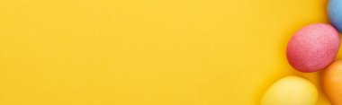 Renkli Paskalya yumurtalarının üst görüntüsü sarı arkaplanda kopya alanı, panoramik çekim