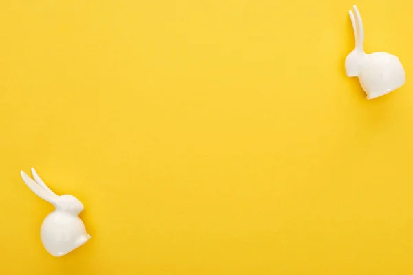 カラフルな黄色の背景に白いイースターバニーのトップビュー — ストック写真