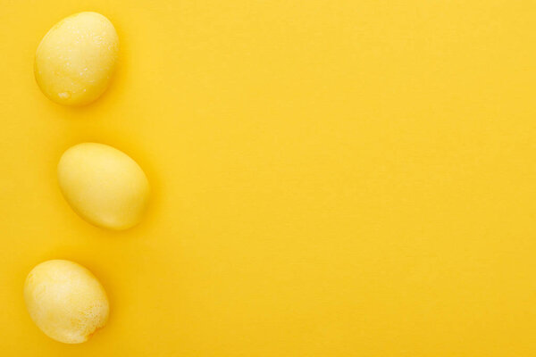 top view of painted Easter eggs on colorful yellow background