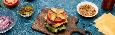 Mavi desenli yüzeyde taze hamburger malzemeleri, panoramik çekim