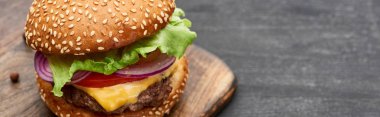 delicious fresh cheeseburger on wooden board, panoramic shot clipart