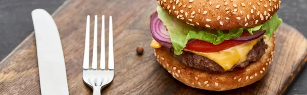 Close Uitzicht Heerlijke Verse Cheeseburger Houten Bord Met Bestek Panoramisch — Stockfoto