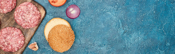 вид сверху на свежие ингредиенты бургера на голубой текстурированной поверхности с копировальным пространством, панорамный снимок
