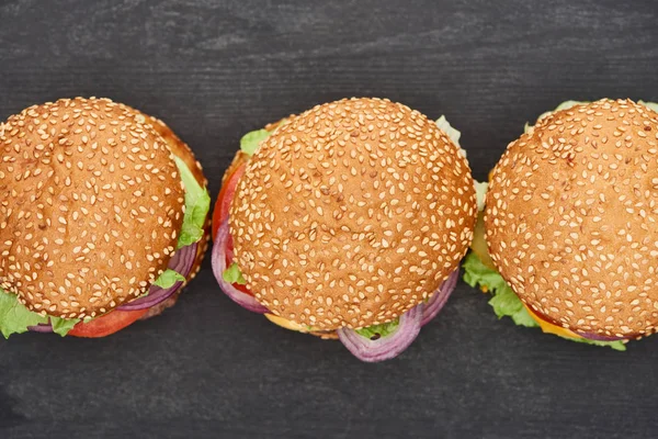 Vista Superior Deliciosos Cheeseburgers Frescos Mesa Preta — Fotografia de Stock