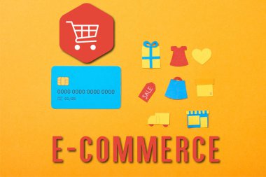 flat lay with blue credit card template near shopping icons isolated on orange with e-commerce illustration