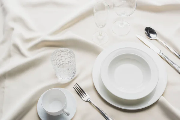 白色桌布上装有眼镜和咖啡杯的餐具的高角形视图 — 图库照片