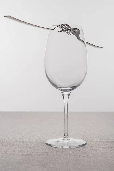 灰色で隔離されたテーブルクロス上の空のワイングラスのフォーク — ストック写真