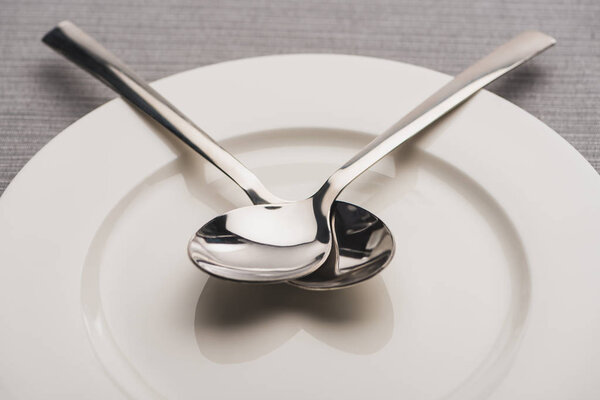 Close up view of spoons on plate on grey surface 