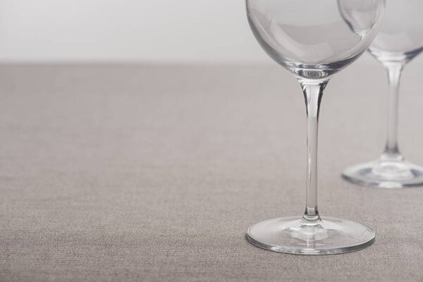 Селективный фокус прозрачных бокалов вина, изолированных на сером
