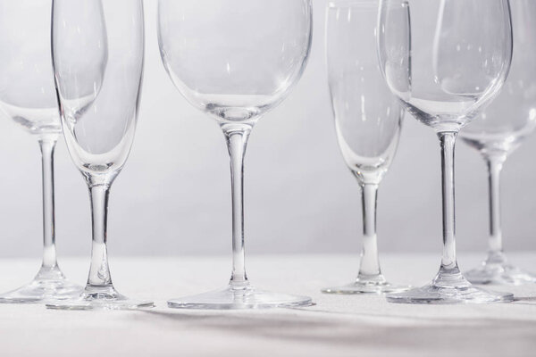 Shiny clear glasses on white surface isolated on grey