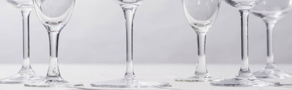 Панорамный снимок вина и бокалов шампанского на белой ткани, изолированной на сером
