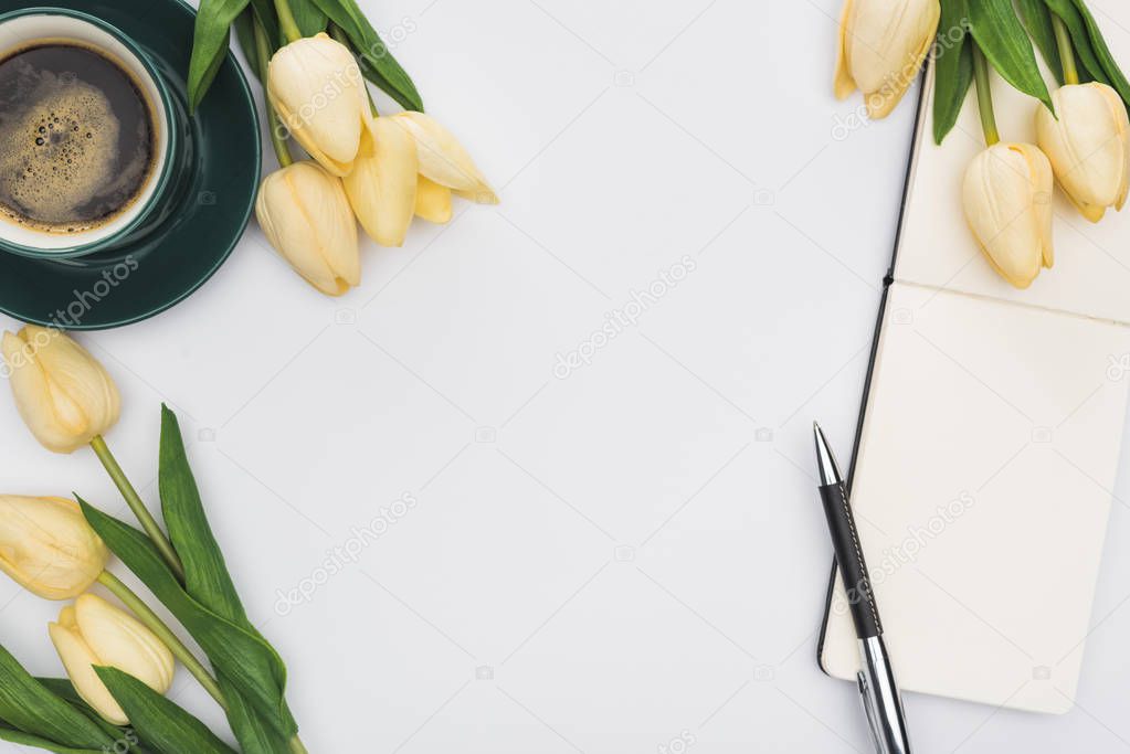 top view of tulips, blank notebook with pen and fresh coffee isolated on white