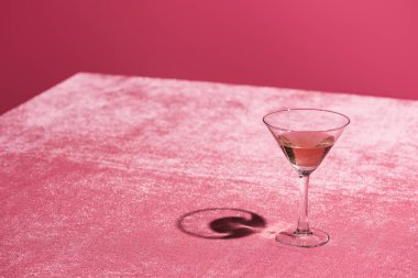 Pembe kadife kumaş üzerindeki kadife bardakta alkol içeceği. Pembe, kız işi bir konsept.