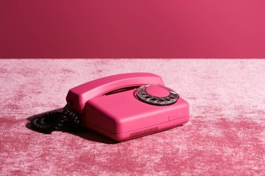 Pembe kadife kumaş üzerindeki klasik telefon. Pembe, kızsı bir konsept.