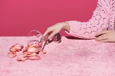 Kırpılmış kadife kumaş üzerindeki cam yapraklarıyla pembe, kızsı bir konsepte izole edilmiş kadın manzarası. 