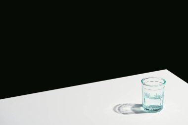 Klasik natürmort hayatı, camda suyla beyaz masada, siyahta izole.