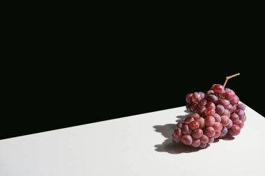 classic still life with grape with shadow on white table isolated on black clipart