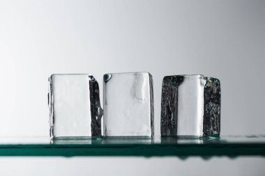 Beyaz üzerinde izole edilmiş şeffaf temiz kare buz küplerinin seçici odak noktası