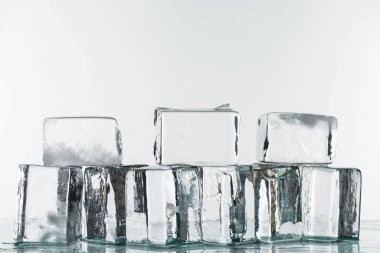 Beyaz üzerinde izole edilmiş şeffaf temiz kare buz küpleri eriyor