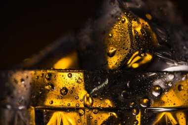 Islak camlı ve sarı ışıklı kare buz küpünün görüntüsünü kapat