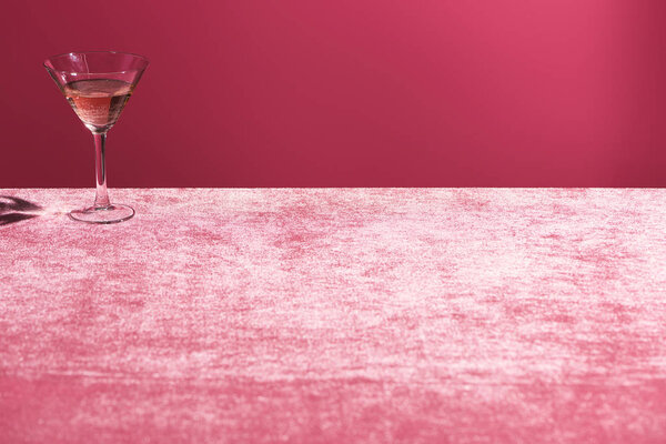 алкогольный напиток в стекле на велюре розовая ткань изолированы на розовый, девичий концепции
