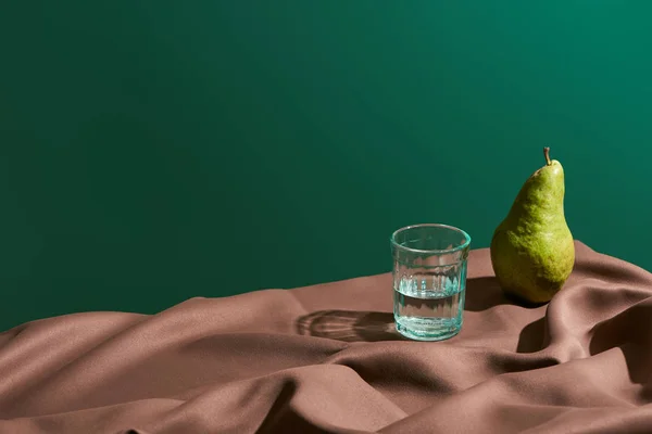 Klasická Zátiší Hruškami Vodou Skle Stole Hnědým Ubrusem Izolovaným Zelené — Stock fotografie