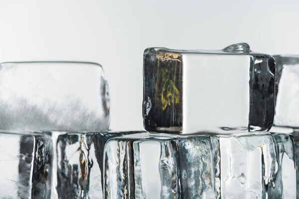 close up view of melting transparent clear square ice cubes isolated on white
