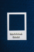 horní pohled na klasické modré písmo na kostkách a bílé foto rámeček texturované modré pozadí