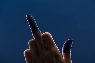 cropped view of female hand with wet painted fingers showing middle finger isolated on blue clipart
