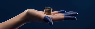 Kırpılmış kadın eli, mavi panoramik çekimde izole edilmiş bozuk paraları tutan boyanmış parmaklar.