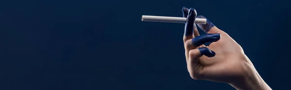 青いパノラマのショットに隔離されたタバコを保持塗装指で女性の手のクロップドビュー — ストック写真