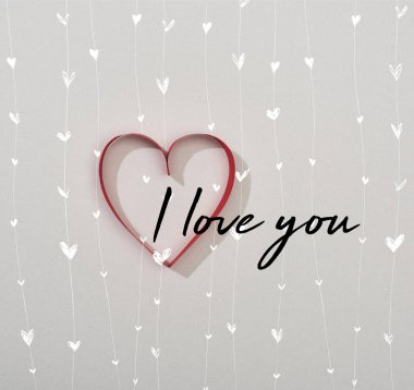 Top view of red paper heart on grey background with i love you lettering