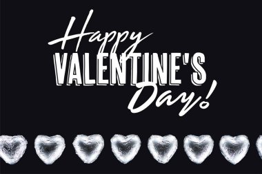 Top view of heart shaped candies isolated on black with happy valentines day lettering