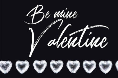 Top view of heart shaped candies isolated on black with be mine valentine illustration