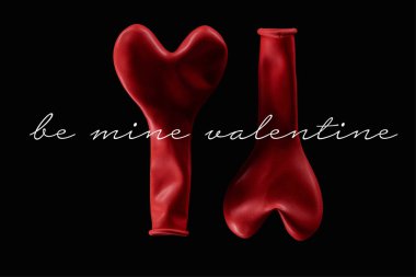 Top view of two red balloons in heart shape isolated on black  with be mine valentine lettering