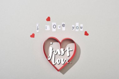 Top view of paper hearts with i love you lettering and just love illustration on grey background