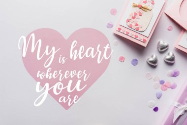 top view of valentines decoration, greeting card, hearts, confetti on white background with my heart is wherever you are lettering clipart