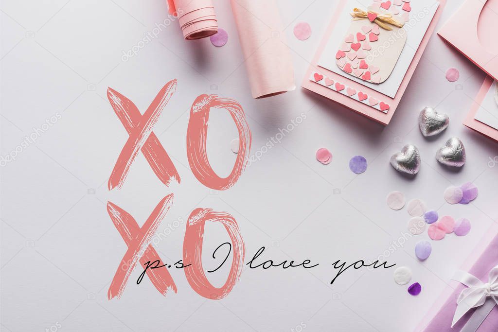 Top view of valentines decoration, gifts, hearts and wrapping paper on white background with xoxo ps i love you lettering