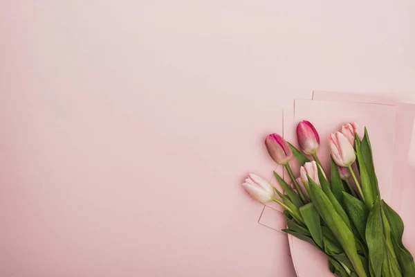 Horní Pohled Růžové Fialové Tulipány Zabalené Papíru Růžovém Pozadí — Stock fotografie