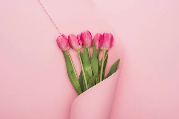 Bovenaanzicht Van Roze Tulpen Gewikkeld Papier Werveling Roze Achtergrond — Stockfoto