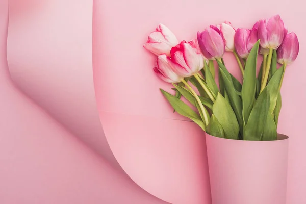 Vista Superior Tulipanes Envueltos Papel Remolino Sobre Fondo Rosa — Foto de Stock