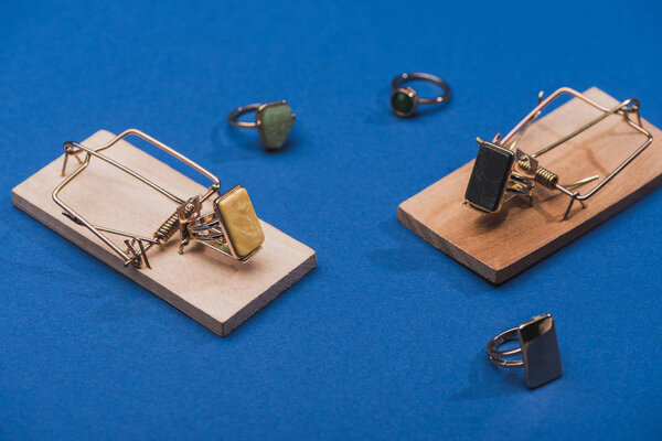 Крупный план ювелирных колец с драгоценными камнями и мышеловками на синем фоне
