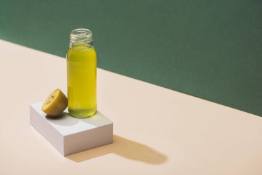 fresh juice near kiwi and and white cube on green and white background